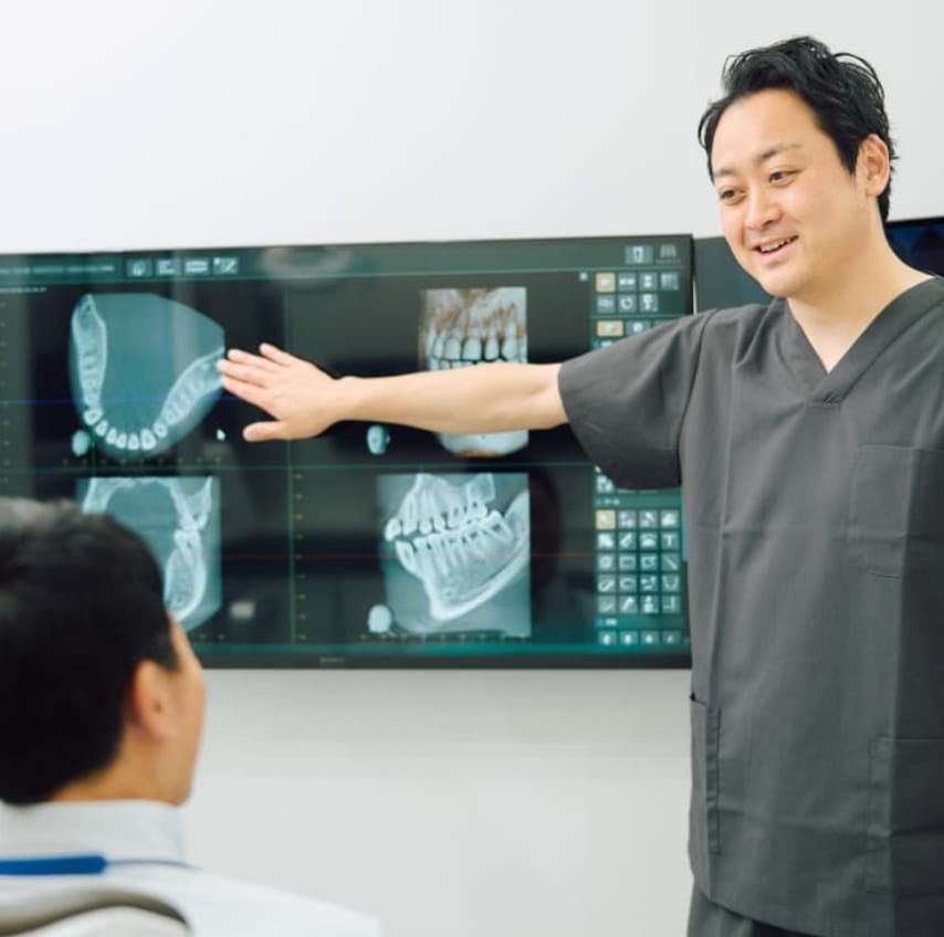 国分寺の歯医者、こばやし歯科医院の院長が患者さんに説明している様子